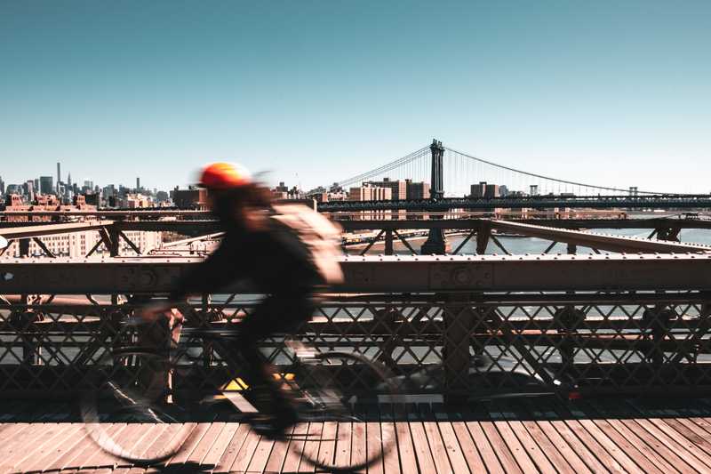 Radfahrer auf Brooklyn Bridge auf dem Weg zur Arbeit