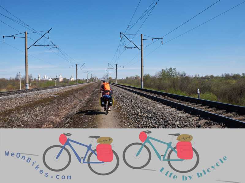 Fahrradfahrer zwischen Bahnschienen in Wologda und Weonbikes-Logo